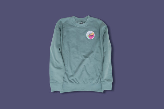 Image of teal crewneck with embroidered patch.