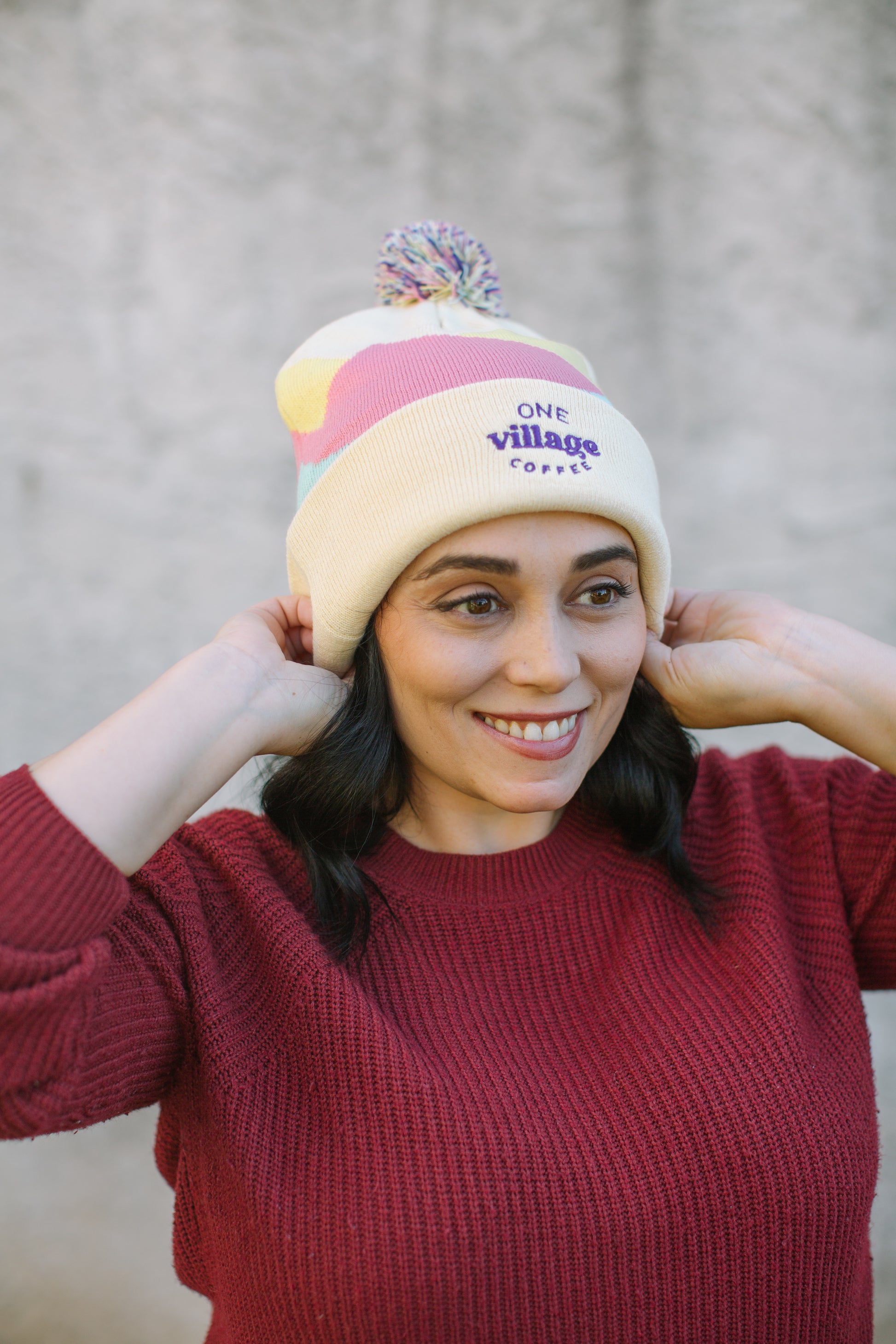 Image of a woman smiling with a knit beanie on her head.