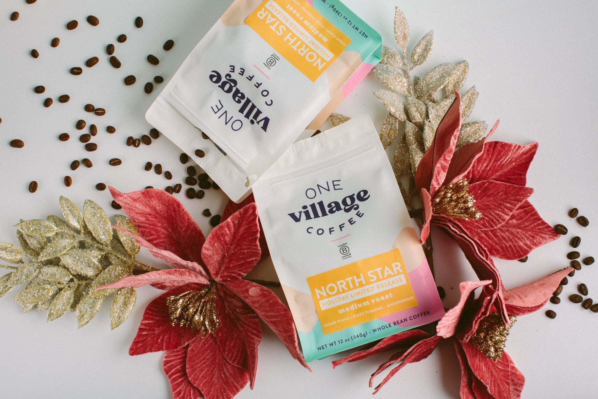 Image of two North Star coffee bags surrounded by coffee beans and poinsettas.