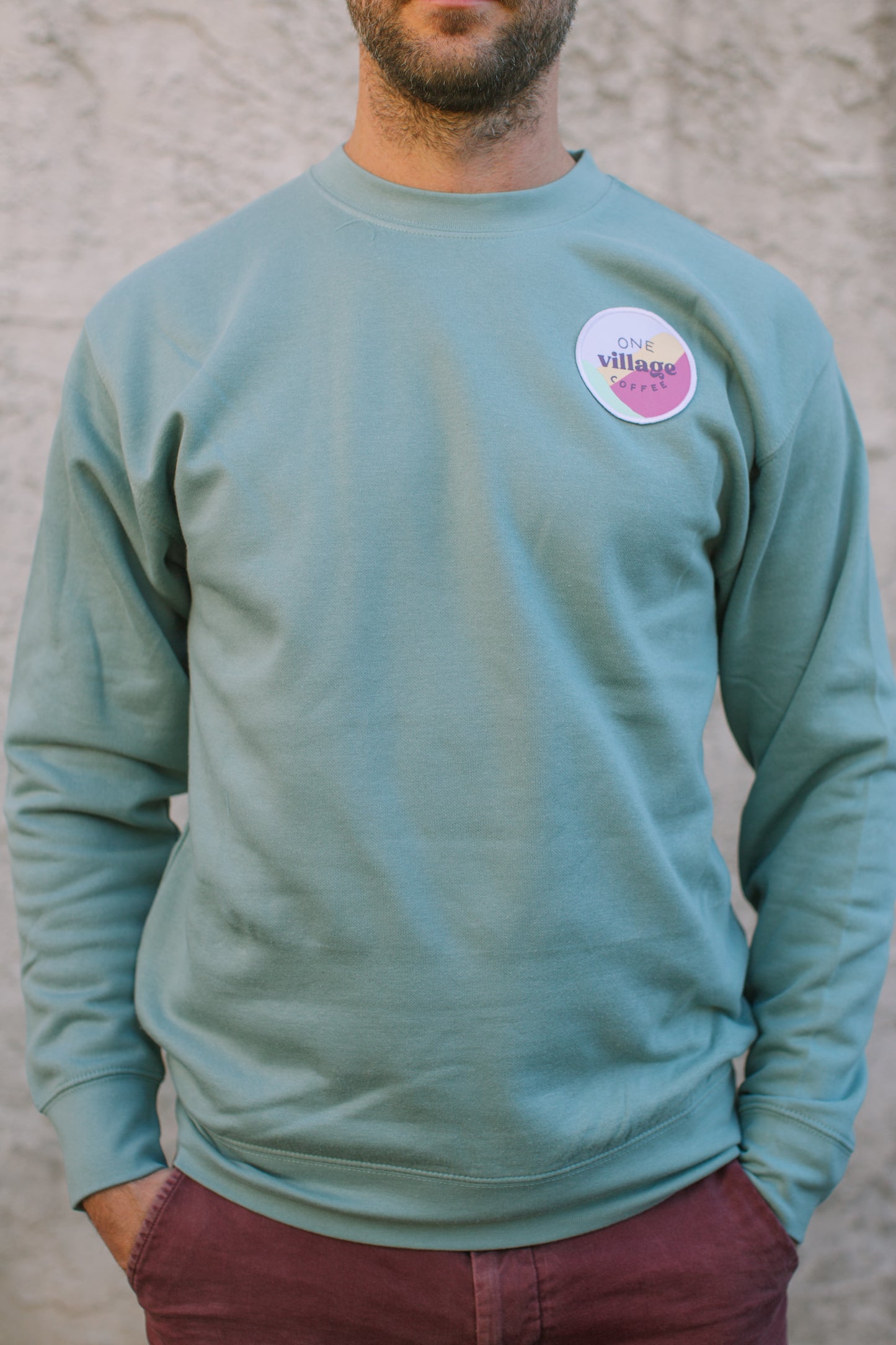 Image of male fit of One Village Coffee crewneck.