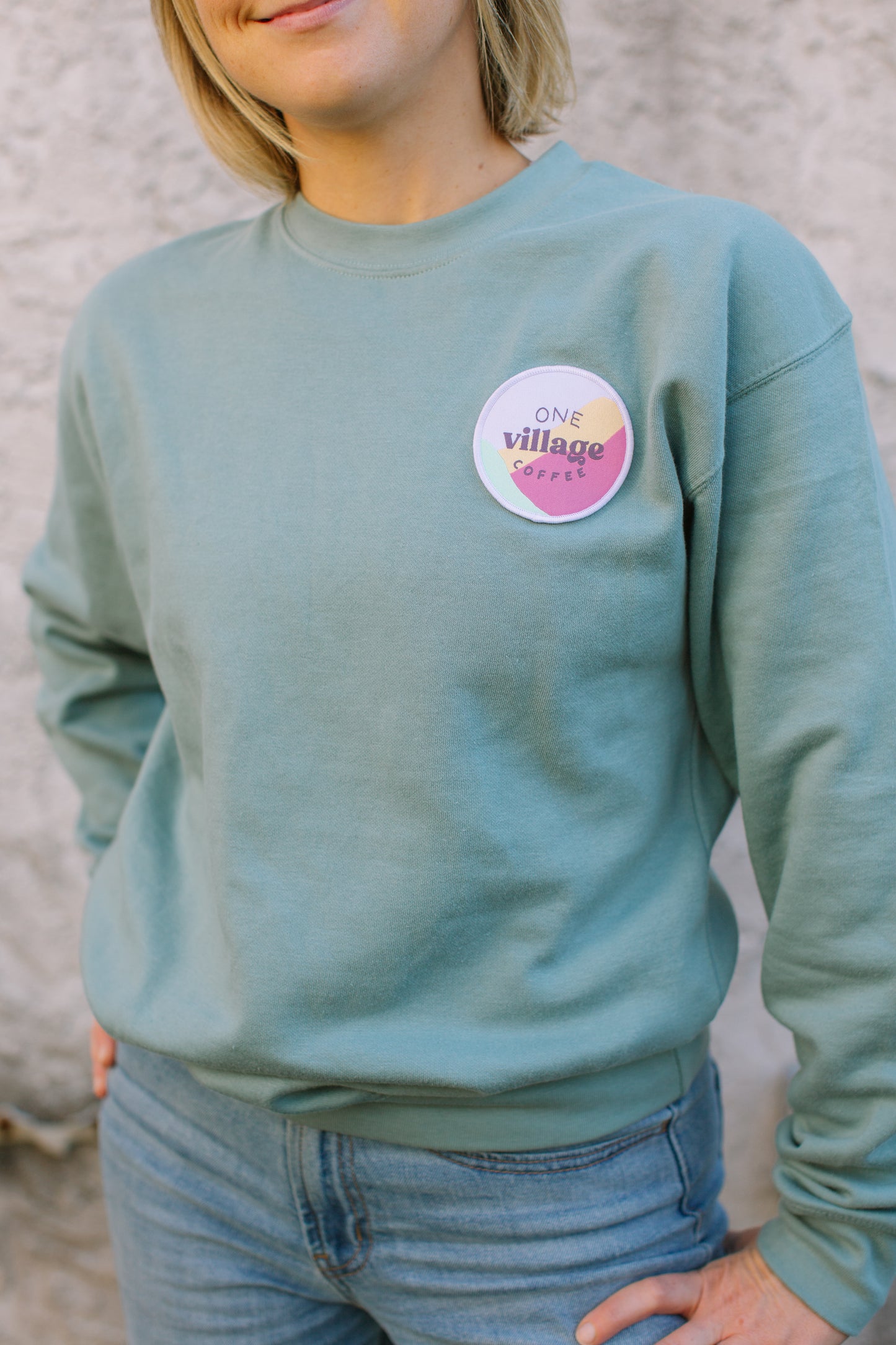 Image of female fit of One Village Coffee crewneck.